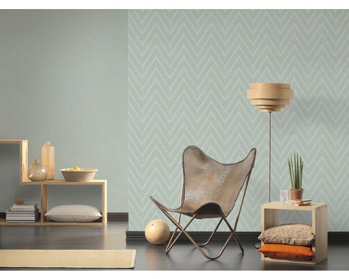 Woonkamer met patroonbehang, fauteuil en bijzettafel