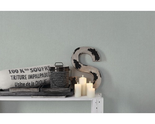 Decoratieve scène met kussen, blik, kaarsen en een ''S'' op een plank