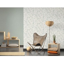 Woonkamer met bloemenbehang, fauteuil en houten elementen