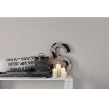 Decoratieve scène met kussen, blik, kaarsen en decoratieve letter op een plank