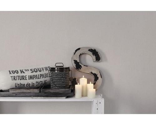 Decoratieve scène met kussen, blik, kaarsen en decoratieve letter op een plank