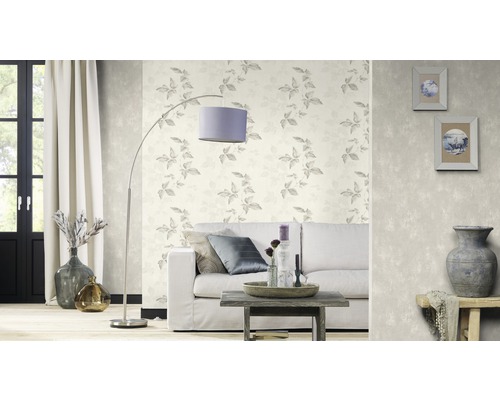 Woonkamer met patroonbehang, bank, staande lamp en decoratieve accessoires voor een stijlvolle interieurinrichting