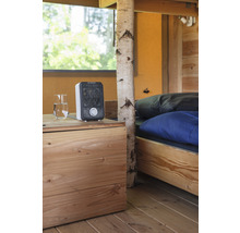 Interieur met bed, houten vloer, nachtkastje, glas water en kachel