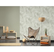 Woonkamer met patroonbehang, fauteuil en rekken.