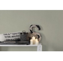 Decoratieve scène met textielzak, blikken emmer, decoratieve letter en kaarsen op een witte plank