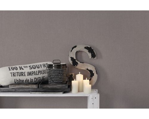 Decoratie met kussen, blik, kaarsen en een grote letter op een plank