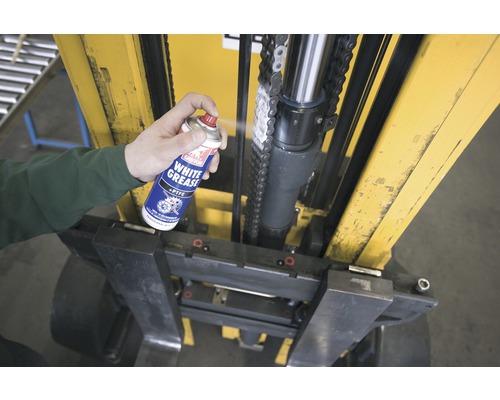 Een persoon spuit wit vet uit een spuitbus op een vorkheftruck