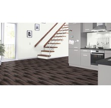 Modern interieur met donkere laminaatvloer, trap met houten treden en grijze keuken.