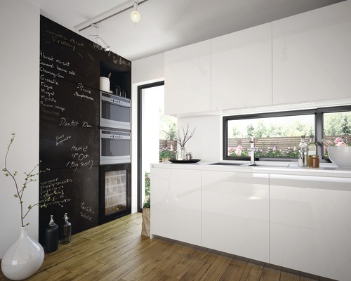 Moderne keuken met witte kasten, krijtbordmuur en houten vloer