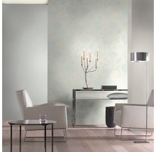 Lichte woonkamer met bloemenbehang, fauteuils en staande lamp.