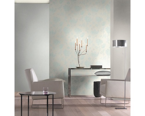 Lichte woonkamer met bloemenbehang, fauteuils en staande lamp.