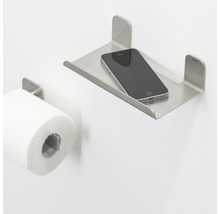 Toilet met toiletpapierhouder en metalen plank met mobiele telefoon