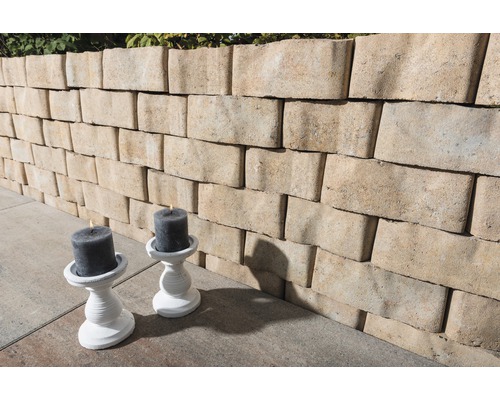 Een muur van muurstenen en twee kandelaars met kaarsen