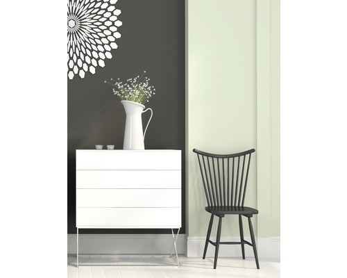 Scene met een witte commode, een vaas met bloemen en een zwarte houten stoel.