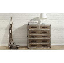 Houten commode met zes laden, decoratie en lamp voor een bakstenen muur