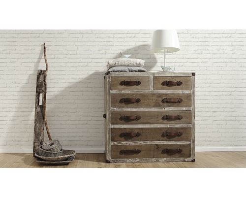 Houten commode met zes laden, decoratie en lamp voor een bakstenen muur