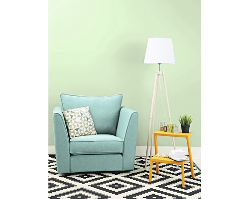 Woonkamer met fauteuil, kussen, staande lamp en vloerkleed met geometrisch motief