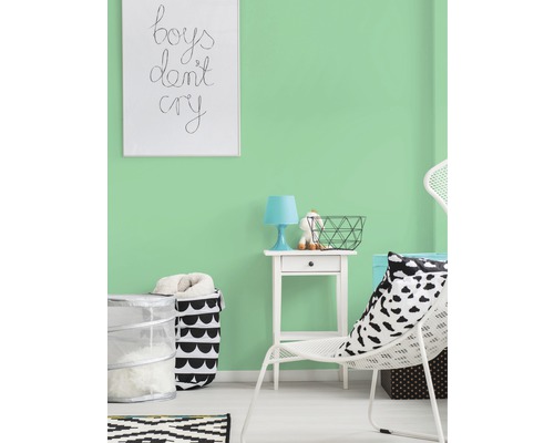 Lichte kamer met mintgroene muurverf, gedecoreerd met witte stoel, nachtkastje en mand