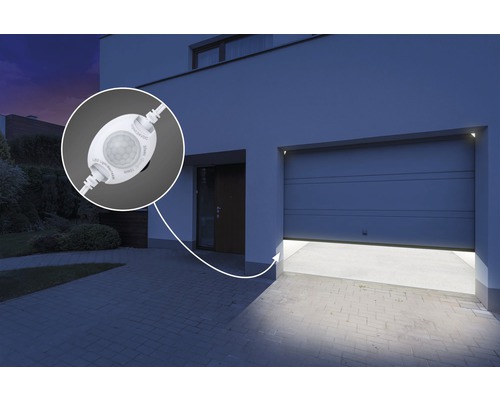 Buitenaanzicht van een huis met een garage die wordt bediend door een bewegingsmelder