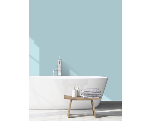 Lichte badkamer met vrijstaand bad, kraan, handdoeken en houten bankje