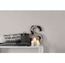 Decoratieve opstelling met kussen, blik, kaarsen en een S op een plank