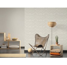 Woonkamer met patroonbehang, fauteuil en houten meubels