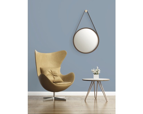 Woonkamer met fauteuil, bijzettafel, spiegel en decoratie