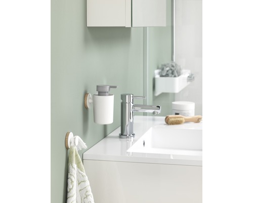 Badkamer met wastafel, kraan, zeepdispenser en handdoekhouder