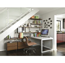 Kantoorinrichting onder een trap met rekken, bureau en bureaustoel in een lichte ruimte