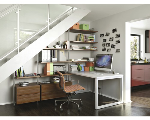 Kantoorinrichting onder een trap met rekken, bureau en bureaustoel in een lichte ruimte
