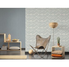 Woonkamer met patroonbehang, fauteuil en houten plank