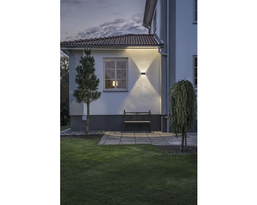 Buitenaanzicht van een huis met tuin en verlichte gevel