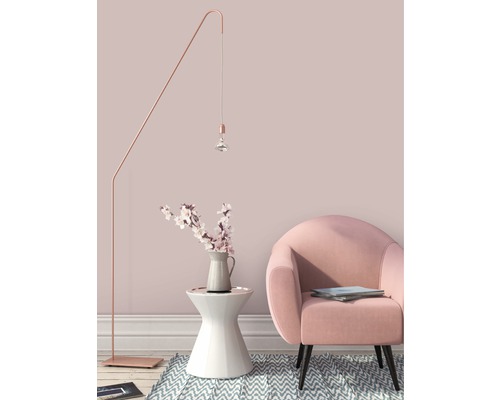 Decoratief interieur met staande lamp, bijzettafel met bloemenvaas en fauteuil.