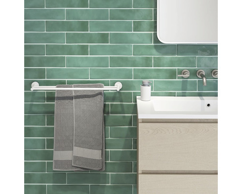 Moderne badkamer met groene tegels, wastafel, handdoekhouder en handdoeken