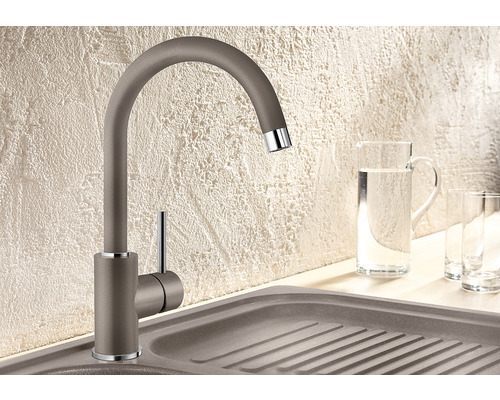 Keukenkraan naast spoelbak met waterkan en glazen