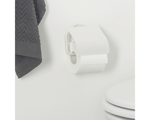 Toiletpapierhouder met toiletpapier en handdoek aan de muur