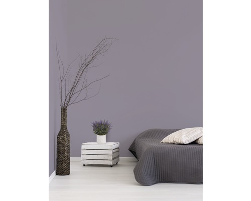 Slaapkamer met bed, houten kist op wielen als nachtkastje, vaas en decoratie