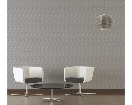 Woonkamer met gestructureerd behang, twee stoelen, een tafel en een hanglamp.