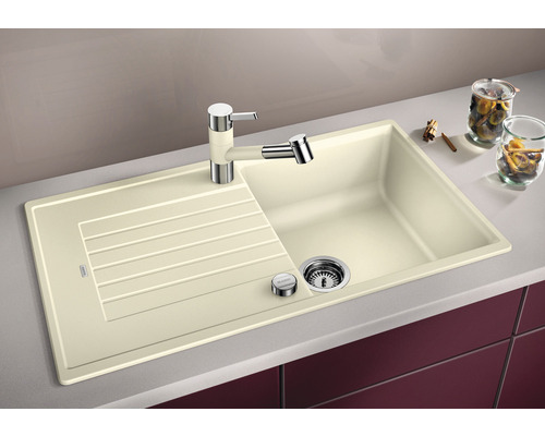 Beige gootsteen met afdruiprek, kraan en zeepdispenser