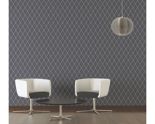 Kamer met patroonbehang, twee stoelen en een hanglamp