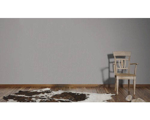 Kamer met houten vloer, koeienhuidtapijt en houten stoel