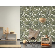Woonkamer met Monstera behang, fauteuil en houten elementen voor een natuurlijke sfeer