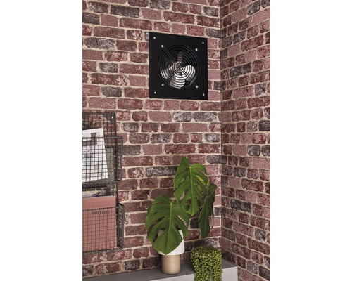 Wandgemonteerde ventilator op een bakstenen muur