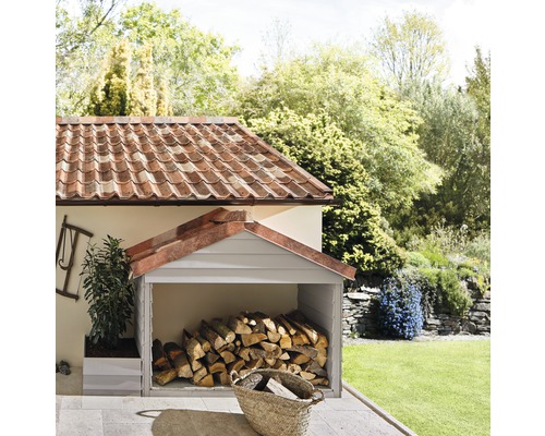 Overdekte houtopslagplaats met brandhout in een tuin.