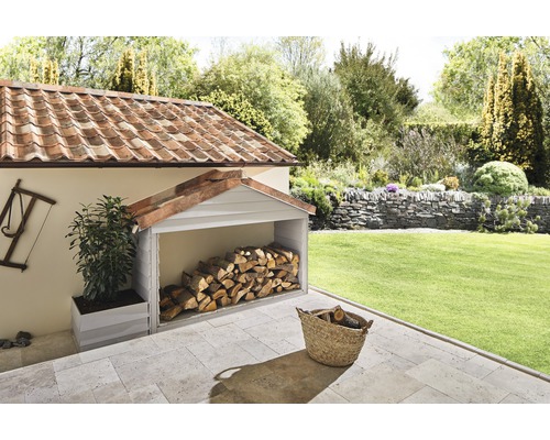 Overdekte houtopslagplaats in de tuin met brandhout en plantenbak