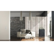 Woonkamer met fauteuil, steenbehang en decoratieve scheidingswand