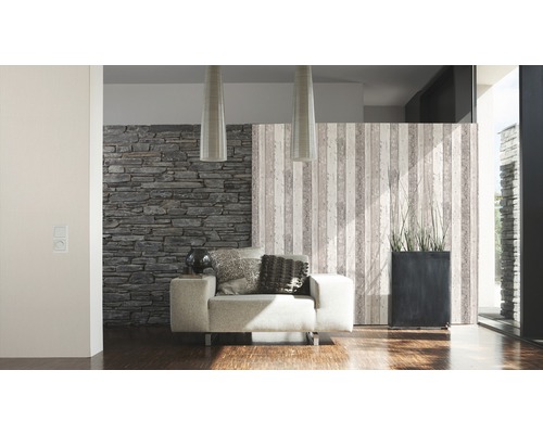 Woonkamer met fauteuil, steenbehang en decoratieve scheidingswand