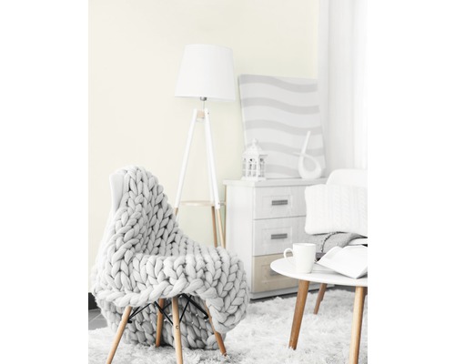 Woonkamer met fauteuil, gebreide deken, staande lamp, bijzettafel en commode