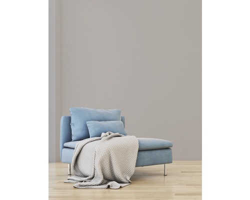 Lichte ruimte met lichtblauwe bank, kussens en gebreide deken