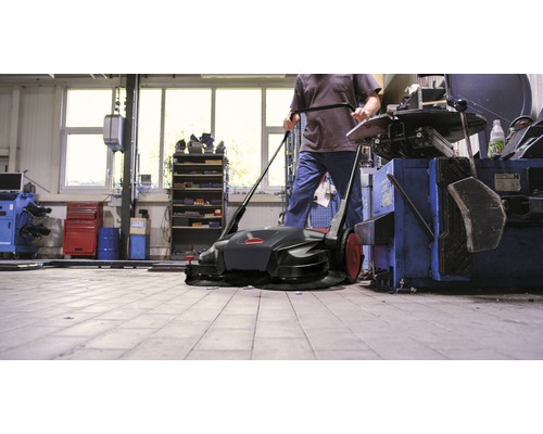 Veegmachine in gebruik in een werkplaats.